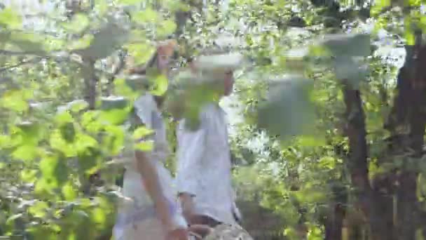 Paar in liefde wandelen in het park of tuin houden handen, emotioneel praten. De man met lang haar en mooie vrouw tijd samen doorbrengen buiten. Retro stijl. Zijaanzicht — Stockvideo