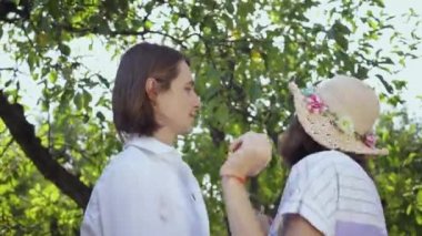 Parkta ya da bahçede dans eden genç bir çiftin yakın çekim. Açık havada, doğayla bağlantı kurarak, güneşli bir günün tadını çıkararak.