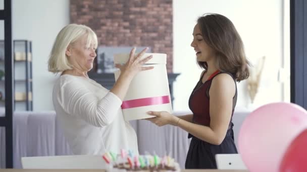 The daughter wishes mom happy birthday and giving her present box with lingerie in it. Women hugging and smiling. Birthday celebration concept. Caring woman giving present to mother — Stock Video