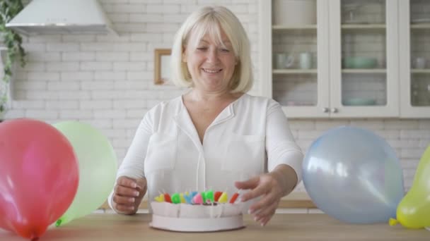 Porträt einer Seniorin, die Kuchen für ihr Kind oder Enkelkind zubereitet. Geburtstagsfeier. Fürsorgliche Oma bereitet Geschenk vor. — Stockvideo