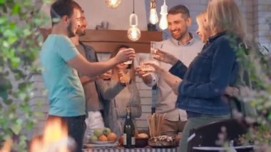 Farklı yaşlardaki insanların alkol alıp arka planda gülümsediği bir şirket. Ön planda yanan alev. Dost aile tatil kutluyor