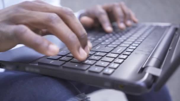 Zbliżenie rąk Afroamerykanina, który szybko pisze na klawiaturze laptopa. Pewny siebie biznesmen lub menedżer pracujący na zewnątrz — Wideo stockowe