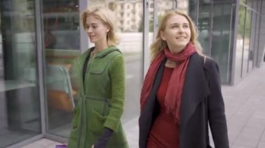 İki sevimli kız arkadaş dışarıda. Şehirde yürüyen alışveriş poşetleri olan dört moda kadını. Birlikte boş zaman. Kızlar kendi alımları zevk.