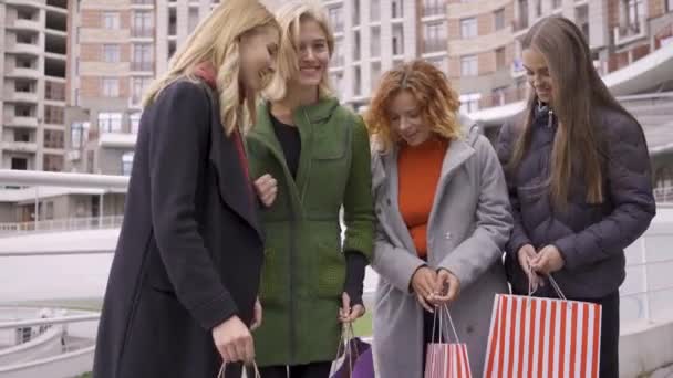 Quattro belle ragazze felici con shopping bags godendo i loro acquisti e mostrando pollici in su. Tempo libero insieme. Shopholism . — Video Stock