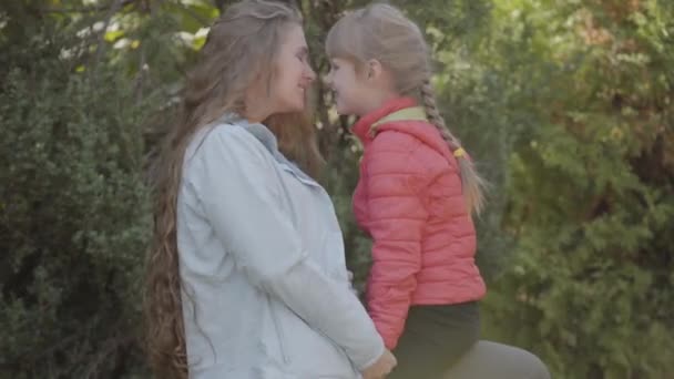 Kaukázusi nő, hosszú szőke hajú palying vele kislány az őszi parkban. Anya és lánya pihenő hétvégén. Boldog család, anyaság, gyermekkor. — Stock videók