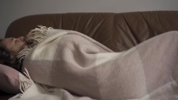 Doente jovem caucasiano tosse enquanto deitado sob cobertor em casa. A criança tem febre. Conceito de saúde, doença, doença, resfriado comum, tratamento — Vídeo de Stock