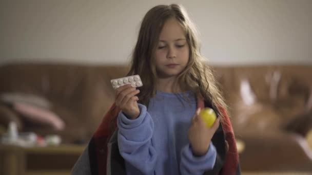 Niño bonito elegir entre pastillas y limón para el tratamiento. Chica alegre caucásica decidiendo tomar el limón y sonriendo. Medicina tradicional y alternativa . — Vídeos de Stock