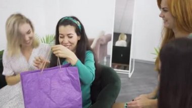 Oldukça beyaz kadınlar hamile arkadaşına verilen hediyelere bakıyorlar. Açık elbiseler içinde dört genç kız hamilelik ve bir çocuğun doğumu hakkında sohbet ediyor. Kadınlar içeride birlikte vakit geçiriyor.