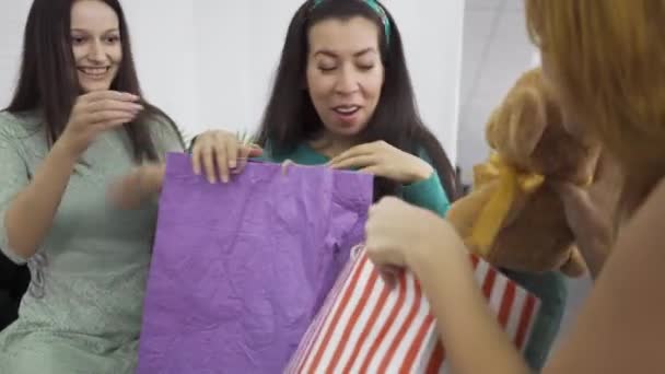 Mujer caucásica embarazada recibiendo regalos de sus dos amigos. Tres niñas preparándose para el nacimiento de un niño. Mujeres celebrando el evento feliz . — Vídeos de Stock