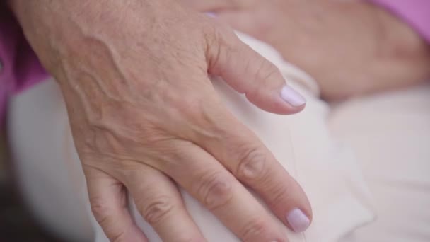 Extrem närbild av mogen kvinnlig hand med mild manikyr smekande hennes knä. Kaukasisk kvinna som lider av smärtan i benet. Äldre människors medicinska problem. — Stockvideo