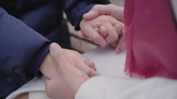 Primer plano de las manos caucásicas maduras femeninas cogidas de la mano de una chica joven. Unidad de abuela y nieta . — Vídeos de Stock