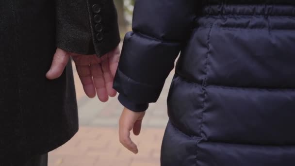 Nahaufnahme einer reifen männlichen kaukasischen Hand, die eine Kinderhand nimmt. Einheit von Großvater und Enkelin. — Stockvideo