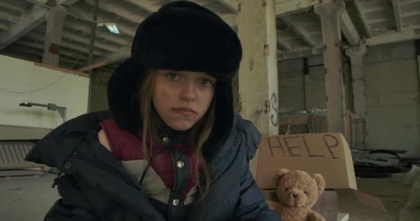 Retrato de una muchacha caucásica sin hogar agotada recibiendo un gran croissant y sonriendo. Hambriento niño cansado teniendo comida para comer . — Vídeos de Stock