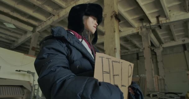 Réfugié syrien en vêtements d'hiver sales debout avec le carton Help et demandant de l'aide. Fille gelée affamée vivant dans la rue . — Video