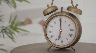 Sabah 7 'de arkasında iki beyaz adamın uyandığı eski moda bir çalar saatin yakın çekimi. Yeni bir mutlu günün başlangıcı.