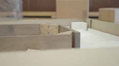 Yeni ahşap mobilya monte eden beyaz erkek ellerinin yakın çekimi. Genç bir aile yeni bir eve taşınıyor ve evlerini döşüyorlar. Yeni yaşam konsepti.