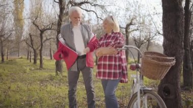Yakışıklı, yaşlı, beyaz saçlı, güzel karısına kırmızı ceket giydiren bir adam. Mutlu yetişkin çiftler haftasonlarını sonbahar parkında ya da ormanda geçirirler. Birlikte yaşlanmak, sonsuz aşk kavramı..