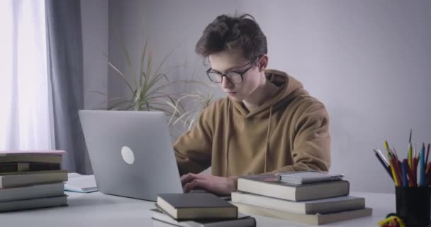 Estudiante universitario cansado quitándose las gafas y frotándose los ojos. Retrato de un chico caucásico estudiando en casa. E-learning, estilo de vida, educación, exceso de trabajo. Sede del cine 4k ProRes . — Vídeo de stock