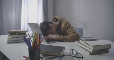 Kafkasyalı üniversite öğrencisi uyanıyor ve dizüstü bilgisayarda klavye yazmaya başlıyor. Evde online çalışan esmer çocuğun portresi. Yorgunluk, yorgunluk, aşırı çalışma, eğitim. Sinema 4k ProRes Merkezi.