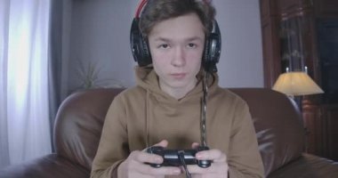 Yorgun solgun bir gencin video oyunu oynarken uykuya dalması. Esmer, beyaz tenli bir çocuğun portresi oyun kontrolüyle gece gündüz ekranın önünde. Bağımlılık, yaşam tarzı. Sinema 4k ProRes Merkezi.