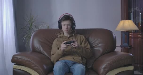 Δυσαρεστημένο αγόρι χάνει στο βιντεοπαιχνίδι. Πορτρέτο του Καυκάσου έφηβου παίζει στο σπίτι τα Σαββατοκύριακα. Τρόπος ζωής, εθισμός στα παιχνίδια, απώλεια. Κινηματογράφος 4k ProRes HQ. — Αρχείο Βίντεο