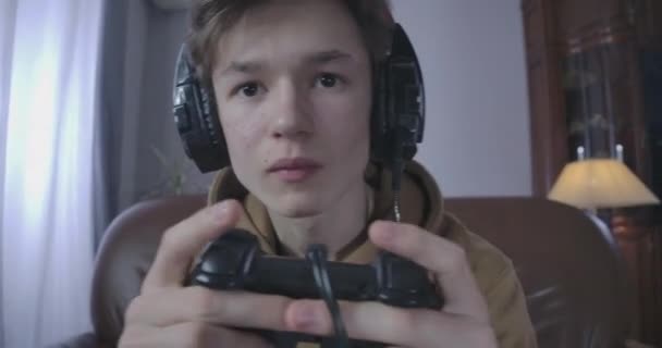 Caméra en direct. adolescent accro jouant à un jeu vidéo. Gros plan de garçon brune caucasien avec console de jeu absorbé par le jeu. Concept de dépendance, adolescence. Siège social Cinema 4k ProRes . — Video