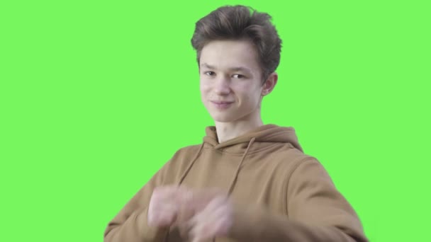 Joyful Caucasian boy pointing at camera with both hands and smiling. Portrait of brunette teenager with brown eyes posing at chromakey background. Lifestyle, emotions, leisure, joy. — Stock Video