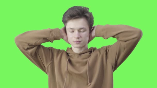 Garçon fermer les oreilles avec les mains et geste non en secouant la tête. Portrait d'un adolescent caucasien qui n'est pas d'accord avec l'écran vert. Adolescence, désaccord, objection. Chromakey . — Video