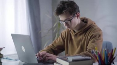 Dizüstü bilgisayarda yazı yazan çalışkan üniversite öğrencisinin portresi. Zeki esmer Kafkas milenyumu internette çalışıyor. E-öğrenme, yaşam tarzı, eğitim, zeka.