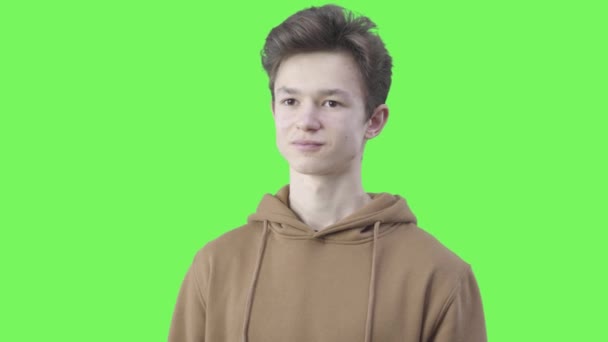Porträtt av vit pojke visar nöje på grön skärm bakgrund. Tonåring som uttrycker tillgivenhet och leende. Chromakey Ordförande. — Stockvideo