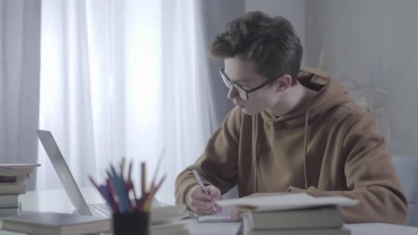Nervös vit pojke gör misstag och kastar bort skrynklig sida. Porträtt av stressade tonåringar som studerar hårt hemma. Utbildning, ungdom, problem, lärande. — Stockvideo