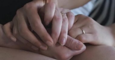 Alyans takan ve birbirini okşayan kadın ellerinin aşırı yakın çekimi. Tanımlanamayan eşcinsel kadın çift avuç içi okşuyor. Homoseksüel, aynı cinsiyet ilişkisi, LGBT yaşam tarzı. Sinema 4k ProRes Merkezi.