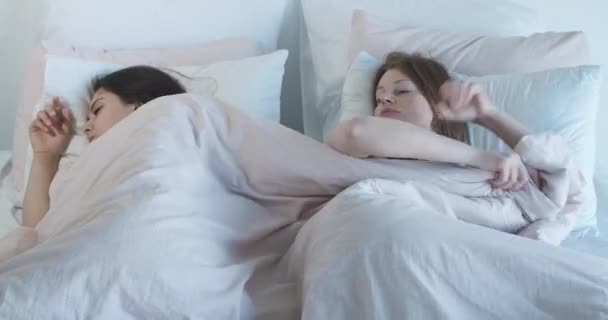 Κάτοψη των λεσβιακών ζευγαριών που τραβάνε την κουβέρτα στο κρεβάτι. Νεαρές λευκές γυναίκες τσακώνονται στην κρεβατοκάμαρα. Σύγκρουση, λεσβιακά προβλήματα, ομοφυλοφιλική οικογένεια. Κινηματογράφος 4k ProRes HQ. — Αρχείο Βίντεο