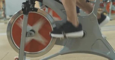 Spor kulübünde pedal çeviren erkek ayaklarının yan görüntüsü. Spor salonunda spor bisikleti üzerinde tanınmayan beyaz sporcu eğitimi. Yaşam tarzı, spor, spor. Sinema 4k ProRes Merkezi.
