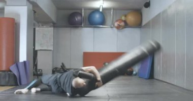 Spor mankeniyle spor salonunda güreş antrenmanı yapan kel, güçlü bir beyaz adam. Kapalı alanda egzersiz yapan genç sporcunun geniş açılı portresi. Sağlıklı bir yaşam tarzı. Sinema 4k ProRes Merkezi.