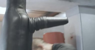 Canlı kamera, sporcuyu mankenle dövüşürken izliyor. Spor salonunda ekipmanlarla güreşen kendine güvenen beyaz bir adam. Kickboks, spor, yaşam tarzı. Sinema 4k ProRes Merkezi.