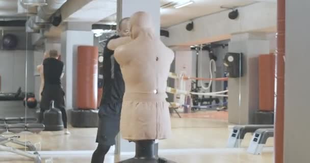 Zweten Kaukasische sportman boksen mannequin in sportclub. Portret van zelfverzekerde sterke man training in de sportschool. Concept kracht, sportieve levensstijl, uithoudingsvermogen. Cinema 4k ProRes Hoofdkwartier. — Stockvideo