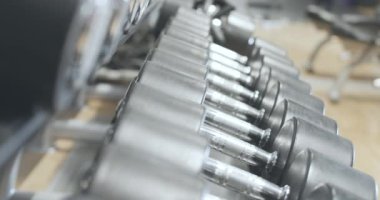 Beden eğitiminde uzanmış el ağırlıkları. Tanınmayan sporcu bir tane alırken. Beyaz adam spor kulübünde ağırlık kaldırıyor. Sağlıklı yaşam tarzı kavramı, spor. Sinema 4k ProRes Merkezi.