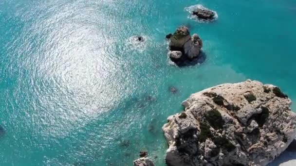 Tampilan atas batuan dalam air pirus biru. Pandangan udara gelombang tenang dari Laut Mediterania Siprus pada hari musim panas yang cerah. Alam yang indah, pemandangan laut, liburan, pariwisata. — Stok Video