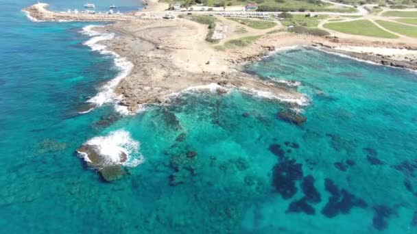 Horní pohled na opuštěné mořské sliny s průhlednými mořskými vodami kolem. Letecký pohled na jasně modré vlny Středozemního moře se skalami na mořském dně. Slunečný letní den na Kypru. Příroda, krása. — Stock video