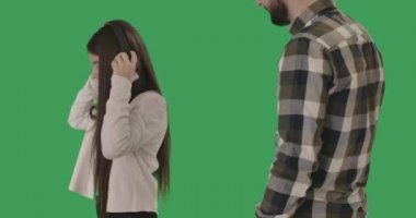 Yaramaz Kafkasyalı genç kız babasına dönüp onu azarlıyor ve baş parmağını kaldırıyor. Kulaklıklı neşeli kız gergin bir adamla çatışmayı görmezden geliyor. Kromakey, yeşil ekran. Sinema 4k ProRes Merkezi.