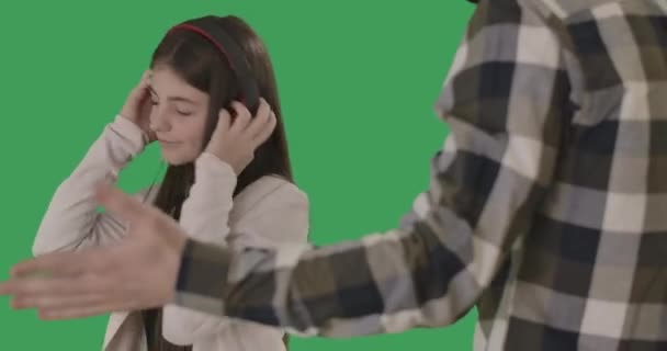 Adolescente mostrando lengua a un padre irreconocible haciendo gestos. Hija caucásica en auriculares ignorando a los padres. Concepto de conflicto de generaciones. Chromakey, pantalla verde. Sede del cine 4k ProRes . — Vídeos de Stock