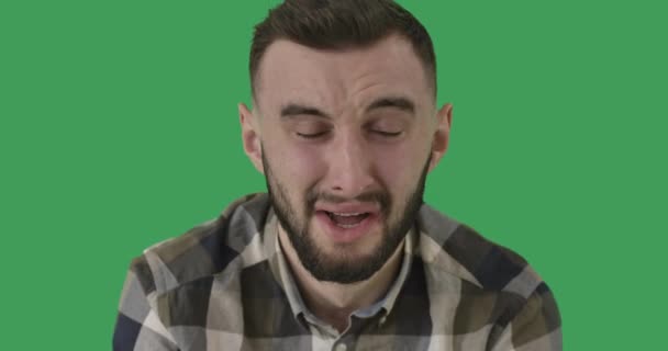 Κοντινό πλάνο ενός άντρα που κλαίει. Πορτρέτο του αναστατωμένου καυκάσιου όμορφου άντρα σε φόντο πράσινης οθόνης. Χρωμάικι. Έννοια της θλίψης, της κατάθλιψης, συναισθηματική ανακούφιση. Κινηματογράφος 4k ProRes HQ. — Αρχείο Βίντεο