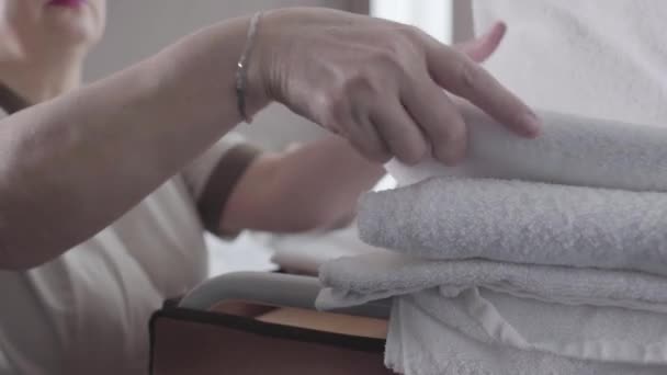 Close-up de mãos femininas tomando toalhas limpas e roupões de banho de carrinho. Empregada de hotel profissional irreconhecível preparando quarto para os visitantes. Profissão, turismo, viajar, estilo de vida, trabalho, emprego . — Vídeo de Stock