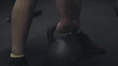 Kamera genç adamın el ağırlığı kaldırışını izliyor. Sportif atletik yakışıklı beyaz sporcu spor salonunda egzersiz yapıyor. Canlı kamera. Spor, halter, vücut geliştirme, erkeklik, yaşam tarzı.