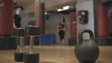 Arka planda spor salonunda el ağırlıkları önde dururken, bulanık atletizm hastaları beşlik çakıyor. Sportif erkekler ve kadınlar spor kulübünde birbirlerini selamlıyorlar. Spor, yaşam tarzı.