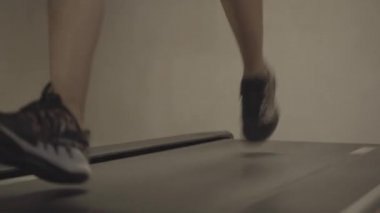 Spor ayakkabılı, koşu bandında koşan beyaz bir erkek. Spor salonunda ekipman kullanarak koşan tanınmamış bir sporcu. Sağlık, yaşam tarzı, spor, spor, kardiyo.