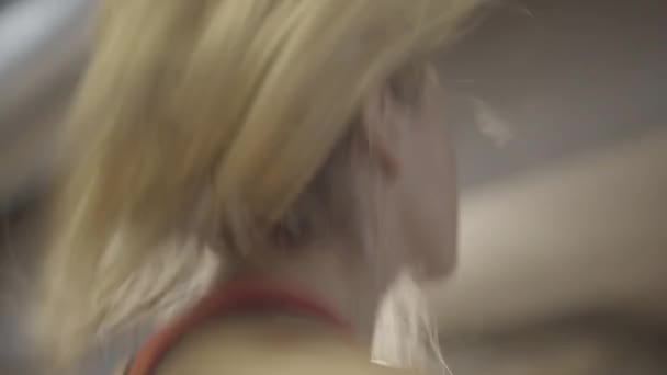 Close-up van een blonde vrouw met paardenstaart die traint op de loopband. Side view van jonge blanke meisje joggen in de sportschool. Schoonheid, gewichtsverlies, sport, gezonde levensstijl. — Stockvideo