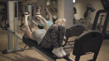 Erkek ve kadın spor salonunda yerçekimi ekipmanları kullanarak çalışıyor. Spor salonunda spor yapan sağlıklı erkek ve kadın sporcuların portresi. Spor, güç, sağlıklı yaşam tarzı, atletizm.