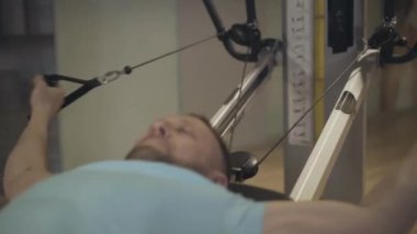 Spor salonunda ekipman kullanarak iyi sakallı sporcu eğitimi almış. Yer çekimi egzersizi yapan gülümseyen beyaz adamın portresi. Güç, sağlık, sağlıklı yaşam tarzı, spor..